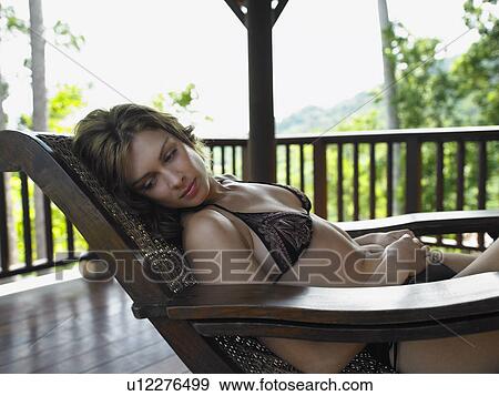 Stock Photo - Thailand, young woman in bikini relaxing in chair. Fotosearch