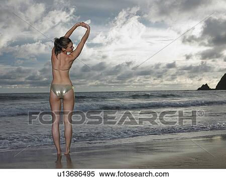 Thailand, young woman in bikini, stretching on beach View Large Photo Image Stock Photography - Thailand, young woman in bikini, stretching on beach. Fotosearch
