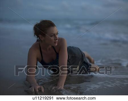 Thailand, young woman lying in surf on beach View Large Photo Image Stock Image - Thailand, young woman lying in surf on beach. Fotosearch