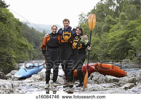 Three people with kayaks by river, portrait View Large Photo Image Stock Photograph - Three people with kayaks by river, portrait. Fotosearch