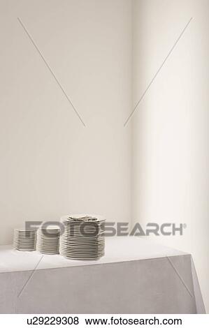Stock Photo - Three stacks of plates and cutlery on table. Fotosearch
