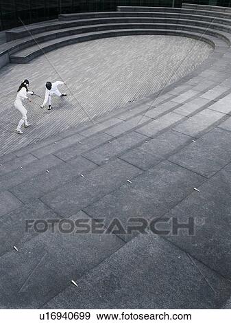 Two athletes fencing in the Scoop amphitheatre, London, England, elevated view View Large Photo Image Stock Photo - Two athletes fencing in the Scoop amphitheatre, London, England, elevated view. Fotosearch
