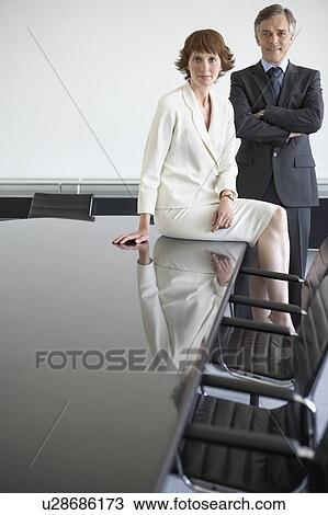 Stock Image - Two business colleagues at conference table, portrait. Fotosearch