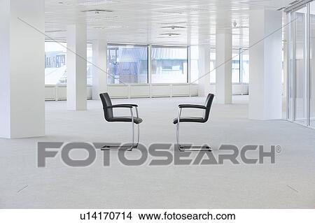 Picture - Two facing chairs in empty office space. Fotosearch