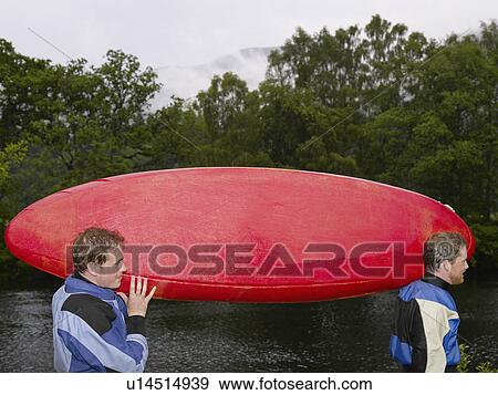 Two men carrying kayak outdoors View Large Photo Image Stock Photo - Two men carrying kayak outdoors. Fotosearch