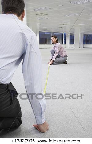 Two office workers measuring floor in empty office space, back view View Large Photo Image Stock Photography - Two office workers measuring floor in empty office space, back view. Fotosearch