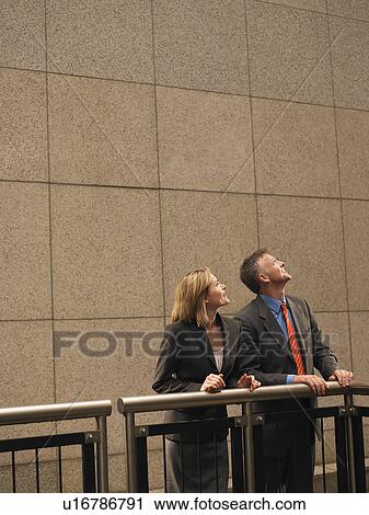 Two people leaning against railing, looking up View Large Photo Image Stock Image - Two people leaning against railing, looking up. Fotosearch