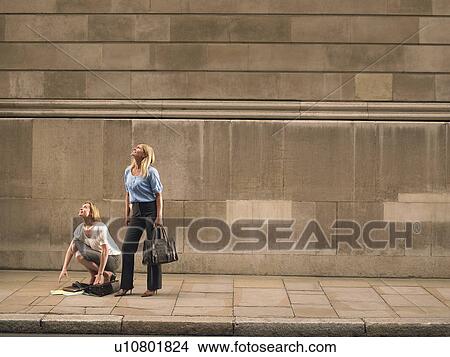 Two women on sidewalk, looking up View Large Photo Image Picture - Two women on sidewalk, looking up. Fotosearch