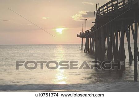 View of sunset over sea with pier View Large Photo Image Picture - View of sunset over sea with pier. Fotosearch