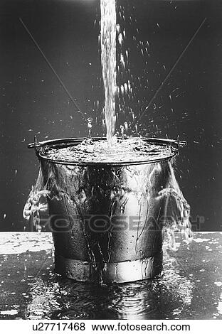 Stock Photo - Water pouring into a bucket, (b&w). Fotosearch