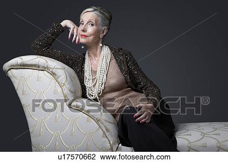 Stock Image - Wealthy Senior Woman on Chaise Lounge. Fotosearch