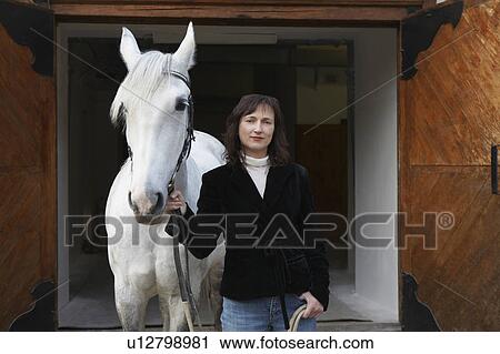 Stock Image - Woman Holding Horse. Fotosearch