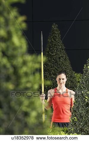 Woman holding javelin, standing in landscaped garden, portrait View Large Photo Image Stock Photo - Woman holding javelin, standing in landscaped garden, portrait. Fotosearch