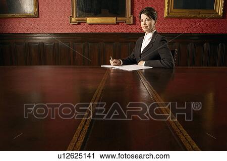 Stock Image - Woman in Conference Room, sitting. Fotosearch