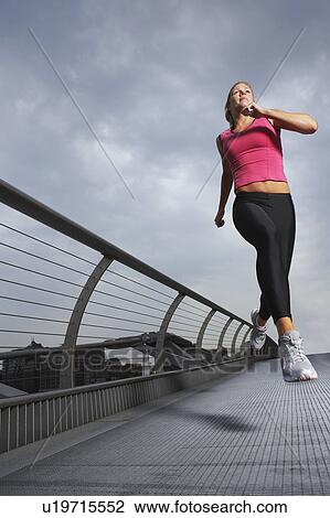 Woman jogging on foot bridge, low angle view, Millennium Bridge, London, England View Large Photo Image Stock Image - Woman jogging on foot bridge, low angle view, Millennium Bridge, London, England. Fotosearch