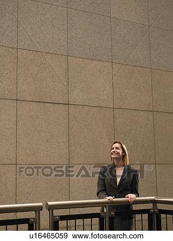 Woman leaning against railing, looking up View Large Photo Image Stock Photo - Woman leaning against railing, looking up. Fotosearch