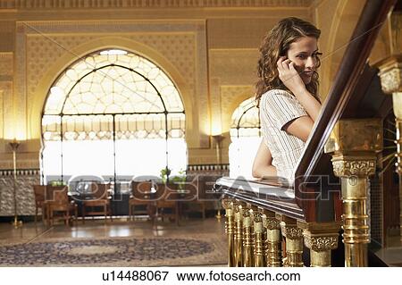 Woman leaning on railing, using mobile phone. View Large Photo Image Stock Photo - Woman leaning on railing, using mobile phone.. Fotosearch