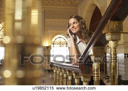 Woman leaning on railing, using mobile phone. View Large Photo Image Stock Photography - Woman leaning on railing, using mobile phone.. Fotosearch