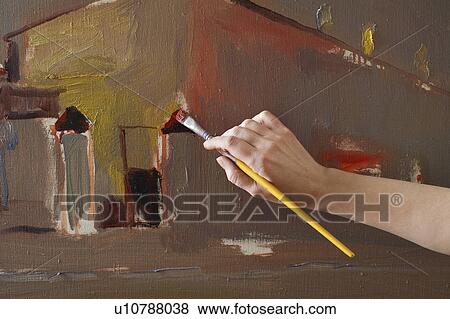 Stock Photo - Woman painting on canvas, close-up of hand. Fotosearch