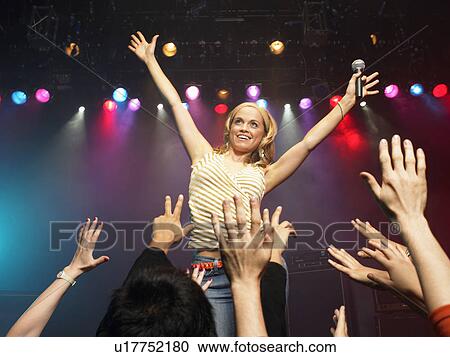 Woman singing in concert on stage in front of adoring fans, low angle view View Large Photo Image Stock Image - Woman singing in concert on stage in front of adoring fans, low angle view. Fotosearch