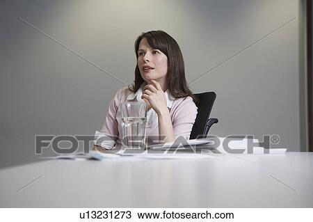 Woman sitting at desk View Large Photo Image Stock Image - Woman sitting at desk. Fotosearch
