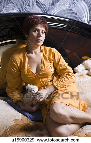 Woman sitting on bed View Large Photo Image Stock Photo - Woman sitting on bed. Fotosearch