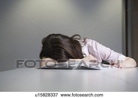 Stock Photo - Woman sleeping at desk. Fotosearch