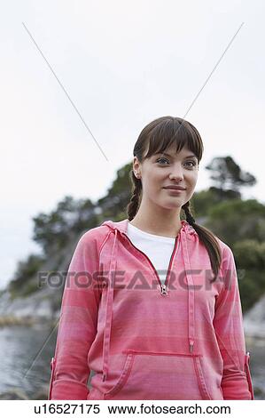 Stock Photography - Woman standing by ocean, portrait. Fotosearch