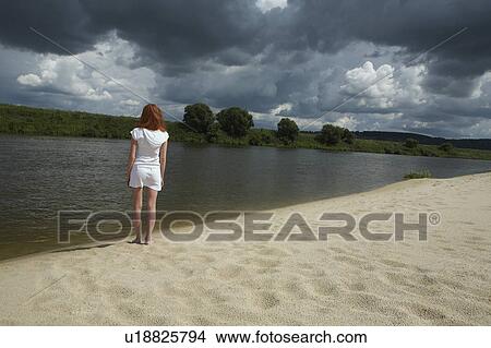 Woman Standing by River under Storm Clouds View Large Photo Image Picture - Woman Standing by River under Storm Clouds. Fotosearch