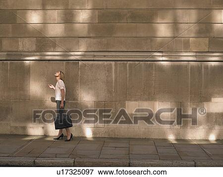 Woman standing by wall, looking up View Large Photo Image Stock Photo - Woman standing by wall, looking up. Fotosearch