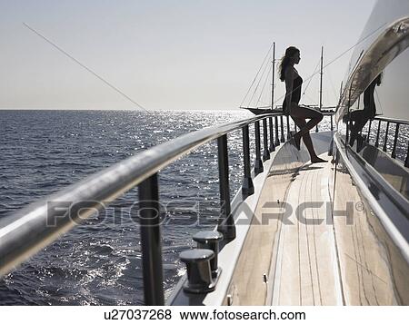 Stock Photo - Woman Standing on Deck of Boat. Fotosearch