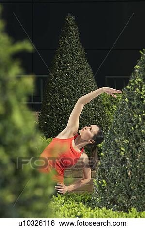 Woman stretching in landscaped garden View Large Photo Image Stock Photograph - Woman stretching in landscaped garden. Fotosearch