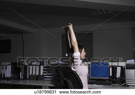 Woman stretching in office, side view View Large Photo Image Stock Image - Woman stretching in office, side view. Fotosearch
