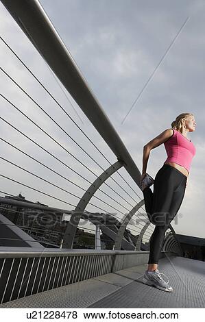 Woman stretching on foot bridge, low angle view, Millennium Bridge, London, England View Large Photo Image Stock Photo - Woman stretching on foot bridge, low angle view, Millennium Bridge, London, England. Fotosearch