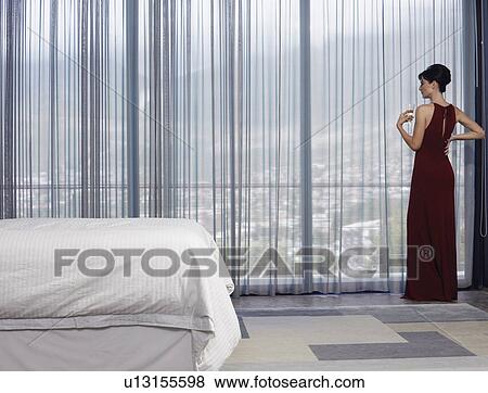 Woman wearing elegant dress looking out of window in bedroom View Large Photo Image Stock Photo - Woman wearing elegant dress looking out of window in bedroom. Fotosearch