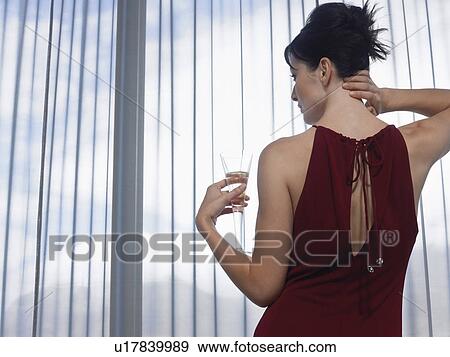 Woman wearing elegant dress looking out of window indoors View Large Photo Image Stock Photo - Woman wearing elegant dress looking out of window indoors. Fotosearch