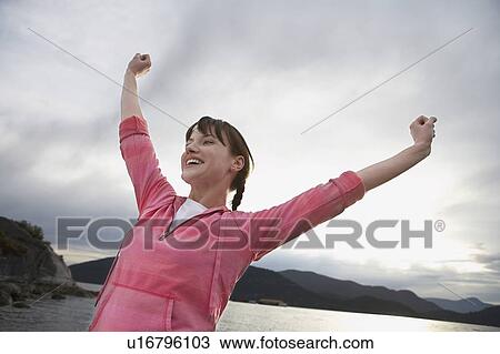 Woman with arms raised at ocean View Large Photo Image Stock Image - Woman with arms raised at ocean. Fotosearch