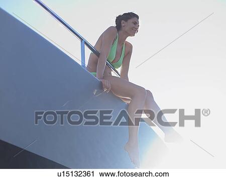 Stock Image - Woman with Feet Hanging from Boat. Fotosearch