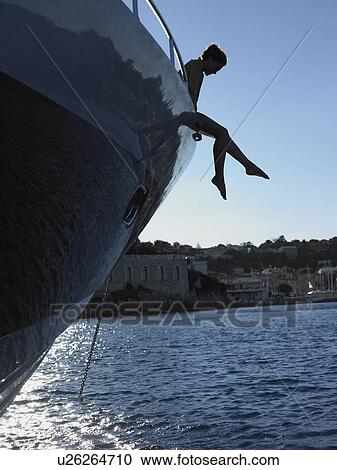 Stock Image - Woman with Feet Hanging from Boat. Fotosearch