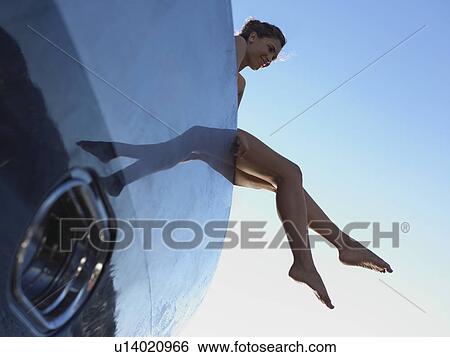 Stock Photograph - Woman with Feet Hanging from Boat. Fotosearch