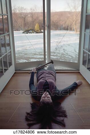 Stock Photograph - Woman with Trumpet Lying in a Doorway. Fotosearch