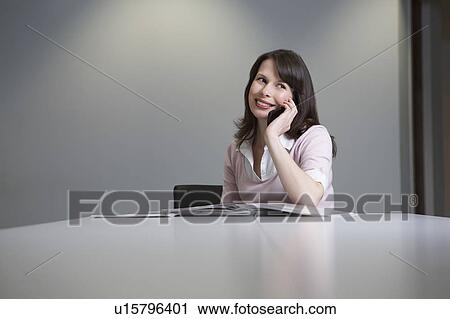 Stock Image - Woman working in office, side view. Fotosearch