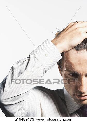 Stock Image - Young Businessman with Hand on Head, close-up. Fotosearch