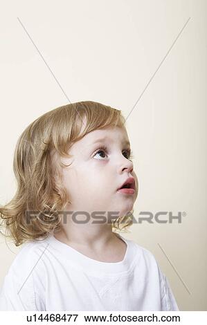 Young child in white t-shirt looking up View Large Photo Image Stock Photo - Young child in white t-shirt looking up. Fotosearch