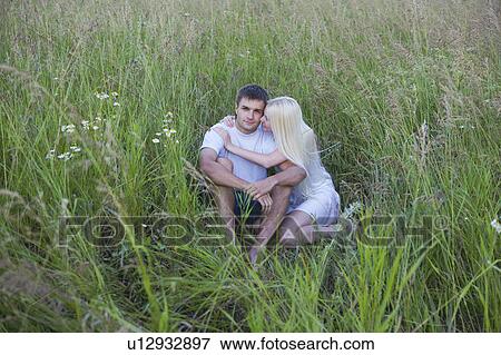 Young Couple Cuddling in Tall Grass View Large Photo Image Stock Photo - Young Couple Cuddling in Tall Grass. Fotosearch