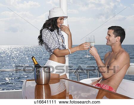 Young couple drinking champagne on yacht View Large Photo Image Stock Image - Young couple drinking champagne on yacht. Fotosearch