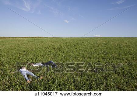 Young Couple Lying in Empty Field View Large Photo Image Stock Photo - Young Couple Lying in Empty Field. Fotosearch