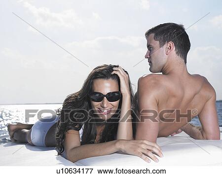Young couple relaxing on cushions on yacht View Large Photo Image Stock Photo - Young couple relaxing on cushions on yacht. Fotosearch