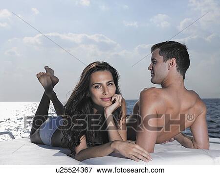 Young couple relaxing on cushions on yacht View Large Photo Image Stock Photo - Young couple relaxing on cushions on yacht. Fotosearch