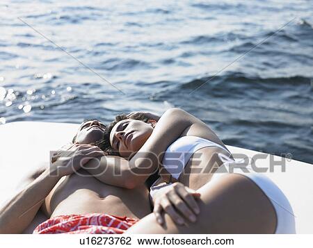 Stock Image - Young couple relaxing on yacht. Fotosearch